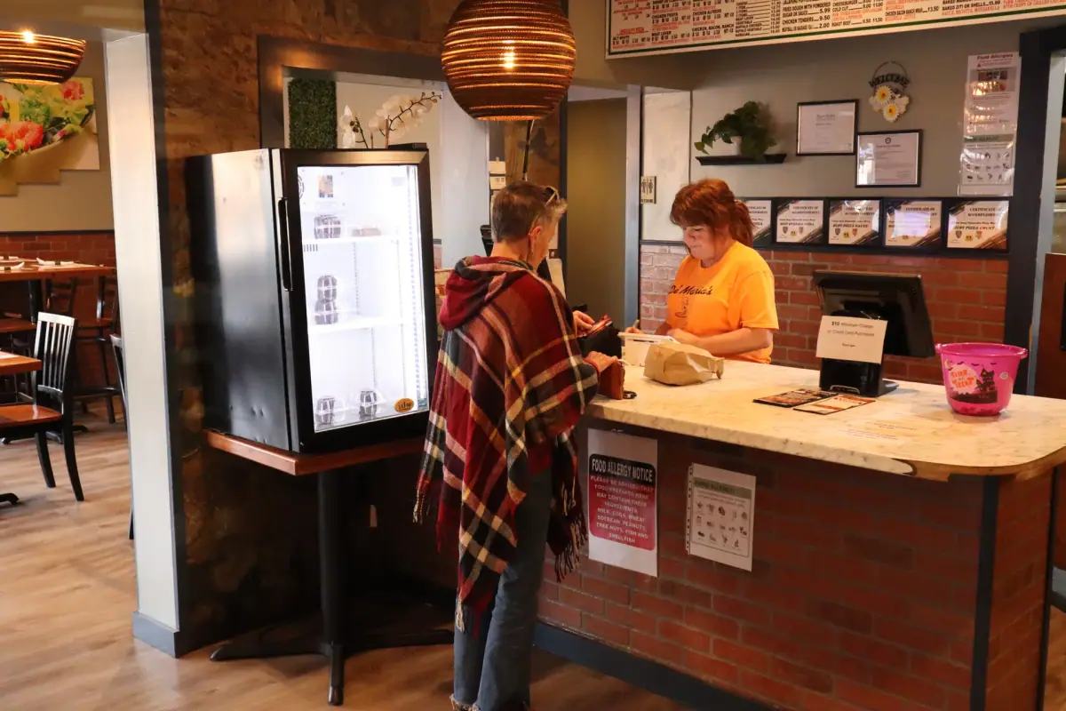 Customer taking out a food order from Royal Xperience De'Maria