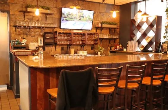 Granite bar with TV, glassware and bar stools