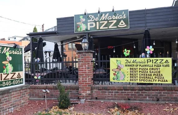 Storefront with green awnings and the Pizza Wars winner banner